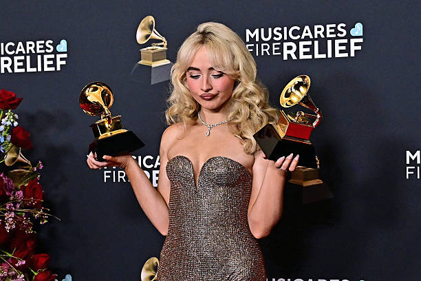 Singer and actress Sabrina Carpenter poses with the Best Pop Vocal Album for "Short n' Sweet" and Best Pop Solo Performance awards in the press room during the 67th Annual Grammy Awards at the Crypto.com Arena in Los Angeles on February 2, 2025. / RESTRICTED TO EDITORIAL USE — frame 3/17 (612×408)