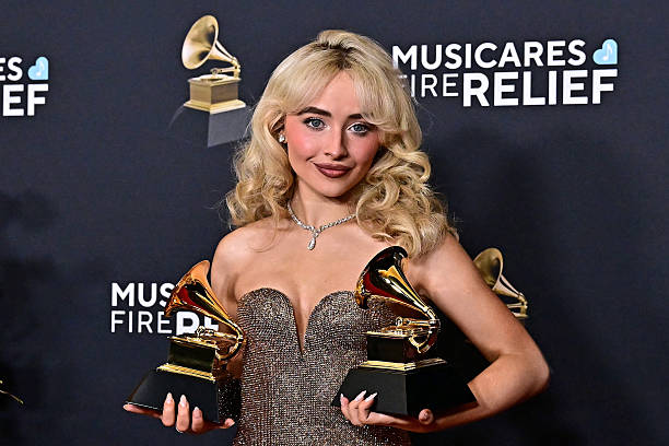 Singer and actress Sabrina Carpenter poses with the Best Pop Vocal Album for "Short n' Sweet" and Best Pop Solo Performance awards in the press room during the 67th Annual Grammy Awards at the Crypto.com Arena in Los Angeles on February 2, 2025. / RESTRICTED TO EDITORIAL USE — frame 1/17 (612×408)